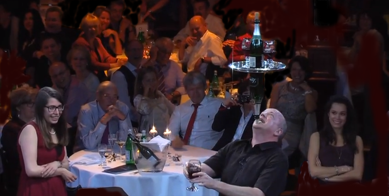 Steve balancing wine bottles and glasses on his chin.